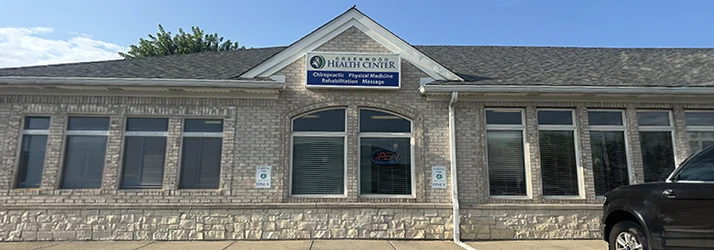 Exterior of Greenwood Health Center, a brick medical building with signage for chiropractic, physical medicine, rehabilitation, and massage services.